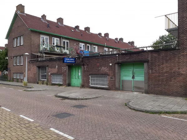 Afbeelding uit: juni 2020. De ingang van de fietsenstalling, met erachter de huizen aan de Middelhoffstraat.