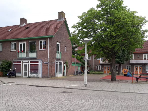 Afbeelding uit: juni 2020. Manenburgstraat 22, hoek Middelhoffstraat. Rechts een deel van de speelplaats op het enige plein in de buurt.