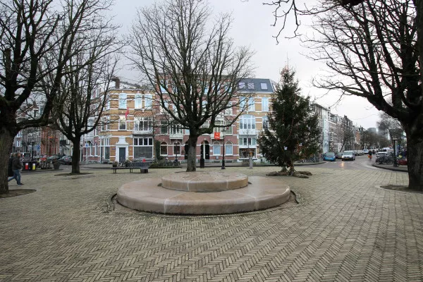 Afbeelding uit: december 2020. Het pleintje op de kruising van Hogeweg (rechts) en Linnaeusparkweg. De huizen in het midden, de zuidwand van het plein, dateren uit 1901 en werden ontworpen door J.H. Lesmeister.