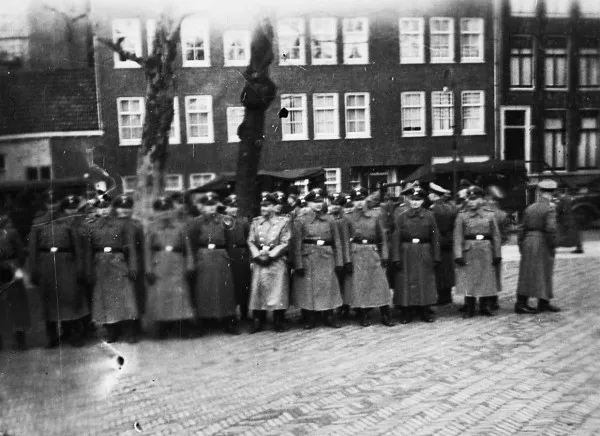Afbeelding uit: februari 1941. Duitse militairen poseren op het plein tijdens de eerste grote razzia in Amsterdam, 22-23 februari 1941. Op de achtergrond overvalwagens en de huizen van Elte.