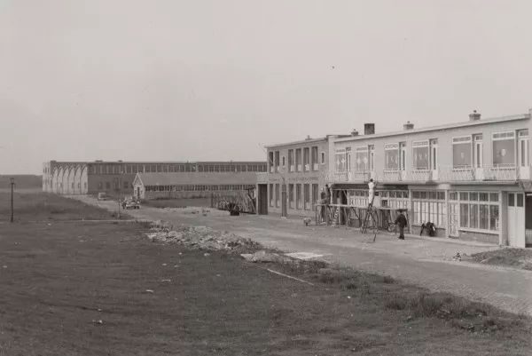 Afbeelding uit: juni 1953. Rechts de nummers 22-24, daarnaast het pand van installatiebedrijf Van Elden. Op de achtergrond de hallen van rijwielfabriek Simplex.
Bron afbeelding: SAA, bestand 010122041102.