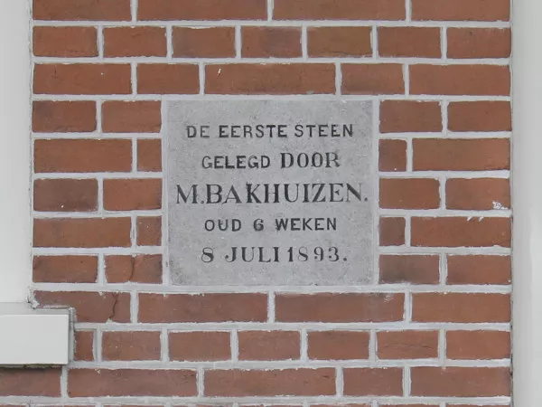 Afbeelding uit: mei 2021. Volgens de tekst werd de eerste steen gelegd door de toen zes weken oude M. Bakhuizen, op 8 juli 1893.