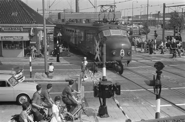 Afbeelding uit: augustus 1962. Gezien naar het oosten. Links het nog bestaande huis Velserweg 24. Achter de trein is het dak te zien van het toenmalige station Sloterdijk. Rechts de Molenwerf.