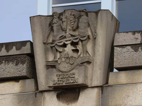 Afbeelding uit: januari 2022. Het linker plastiek, met symbolen van handel en scheepvaart. In Griekse letters staat er "psuches iatreion", geneesplaats voor de ziel.