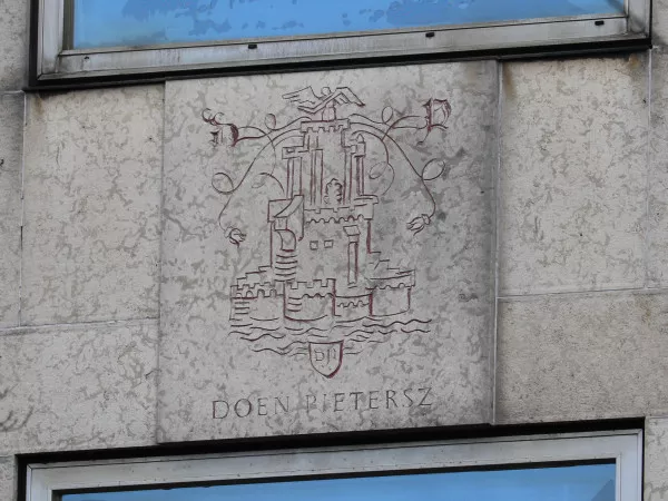 Afbeelding uit: januari 2022. Een van de vier kalkzandstenen platen van Sem Hartz. Deze herdenkt de Amsterdamse drukker, boekhandelaar en uitgever Doen Pietersz, die in het begin van de zestiende eeuw werkzaam was.