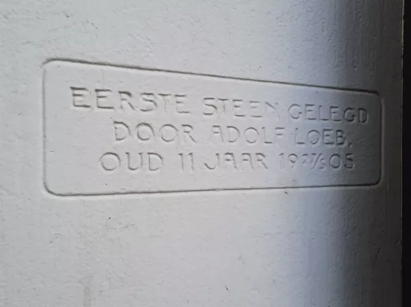 Afbeelding uit: januari 2022. Eerste steen, naast de ingang van Kwekkeboom aan de Linnaeusstraat. "Eerste steen gelegd door Adolf Loeb. Oud 11 jaar 19 ²⁷⁄₃ 05" (27 maart 1905)