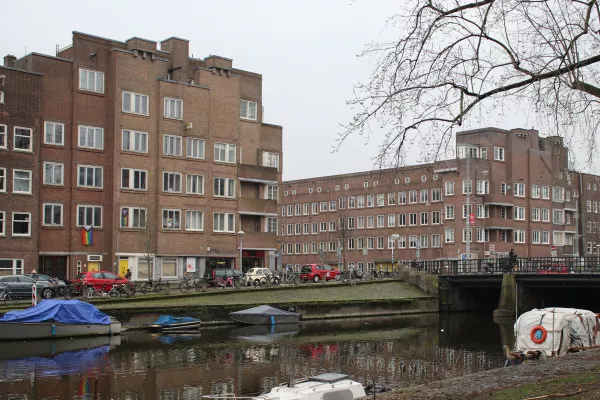 Afbeelding uit: maart 2022. Markante kopzijden van twee blokken aan weerszijden van de Hoofdweg, bij de Erasmusgracht. Van der Mey ontwierp in 1925 de voorgevels i.o.v. Gulden & Geldmaker.