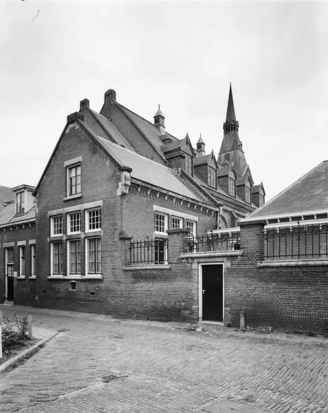 Afbeelding uit: juni 1976. Achtergevel, aan de Nieuwstraat. Op de voorgrond het bouwdeel met pastorie en consistorie.