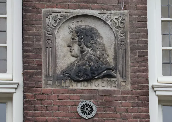 Afbeelding uit: juni 2022. Gevelsteen in de voorgevel. Onderaan staat de tekst Chr. Huygens; bovenaan 1656, het jaar waarin Huygens het slingeruurwerk bedacht.