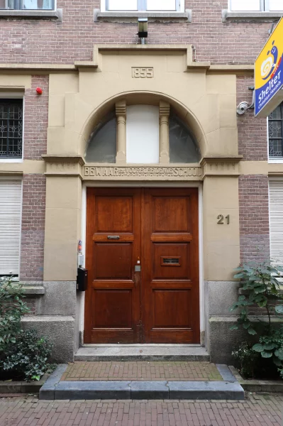 Afbeelding uit: oktober 2022. 1855 is het jaar waarin de vereniging werd opgericht. Boven de deur: "BEWAAR en VOORBEREIDENDE SCHOOL".