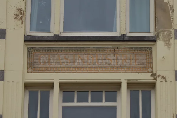 Afbeelding uit: december 2022. In oranje letters "GLASINDUSTRIE", daarachter in witte letters "NV GLASHANDEL".