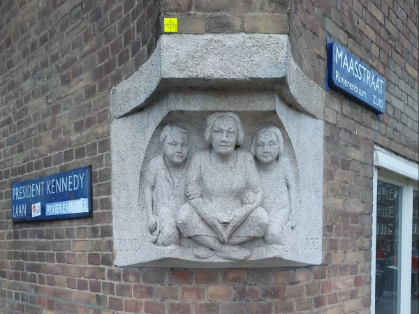 Afbeelding uit: december 2022. Hoek President Kennedylaan - Maasstraat. Zittende vrouw met twee kinderen (1933). Beeldhouwer was Jan Schultsz. Tekst: "Zuid 1933".
