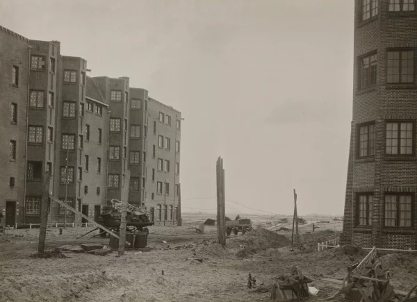 Afbeelding uit: circa 1921. De Bernard Kochstraat gezien vanaf de Krusemanlaan. Voorbij de nieuwe woonblokken stond nog niets.
Bron afbeelding: SAA, bestand OSIM00003005642.