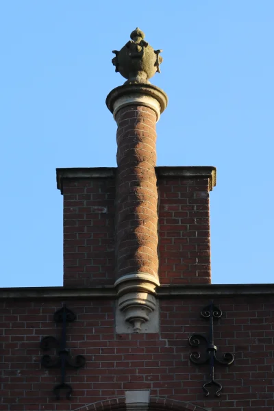 Afbeelding uit: december 2023. De rechter trapgevel is voorzien van een getordeerd zuiltje met daarop een bolvormig ornament.