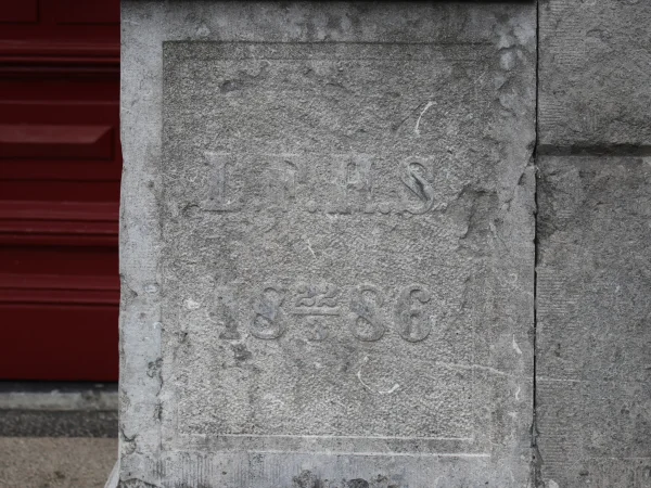 Afbeelding uit: januari 2024. Eerste steen met de tekst "L.F.H.S." en de datum "18 22/3 86".