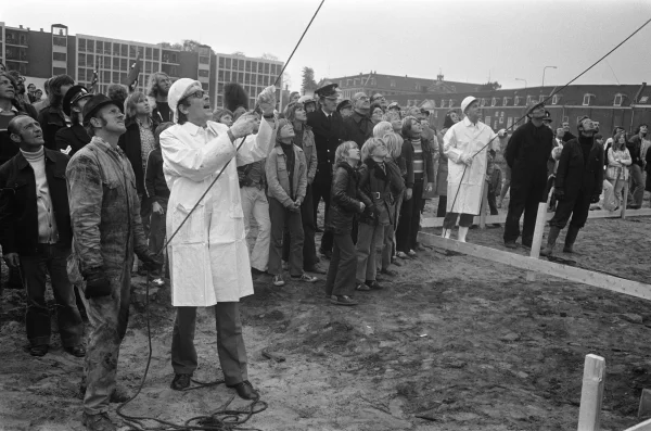 Afbeelding uit: oktober 1973. Op 15 oktober 1973 slaan de in witte jassen geklede wethouders Lammers (links) en Kuijpers de eerste paal.