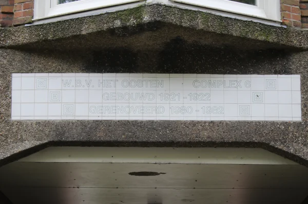 Afbeelding uit: juni 2024. Andere kant van de poort. "W.b.v. Het Oosten complex 6/ Gebouwd 1921-1922/ Gerenoveerd 1980-1982"
