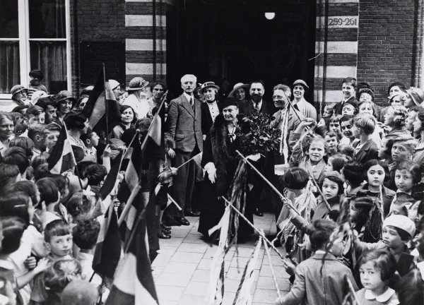 Afbeelding uit: 1938. Maria Montessori (midden) bezoekt de Wilhelmina Catharinaschool.
Bron afbeelding: SAA, bestand OSIM00007005916.