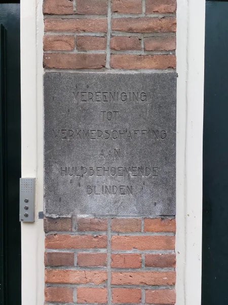 Afbeelding uit: juni 2024. Steen in de gevel van Plantage Badlaan 7-9, met de naam van de vereniging.