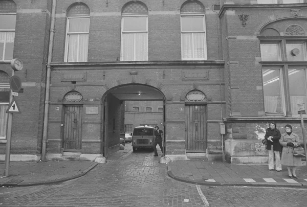 Afbeelding uit: december 1975. De poort aan het Kleine-Gartmanplantsoen. Boven de deuren staat "Portier" en "Conciërge", en daar weer boven "Anno" en "1891". Rechts het toenmalige kantongerecht. (Collectie Noord-Hollands Archief, inv.nr NL-HlmNHA_1478_14278K00_10)