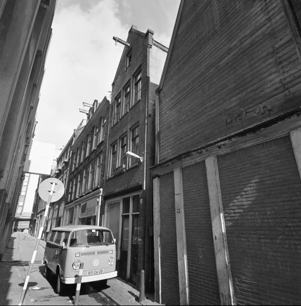Afbeelding uit: circa 1970. In het midden, bij het busje, Sint Jansstraat 21. De resten van nummer 23 werden in 2001 afgebroken.
Bron afbeelding: SAA, bestand BMAB00030000114_007.