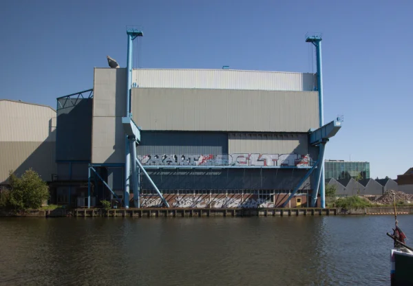 Afbeelding uit: juni 2005. Het montagegebouw (1975-2006), met de blauwe kraanbaan en de zuilen van het hefportaal in oorspronkelijke setting.
