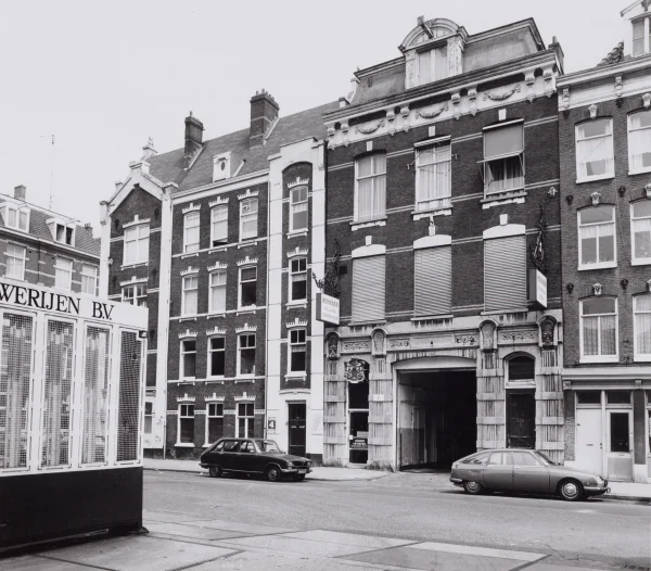 Afbeelding uit: juni 1982. Op het linker uithangbord staat "Heineken Rolluiken Zonweringen".
Bron afbeelding: SAA, bestand 010122031882.