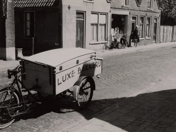 Afbeelding uit: augustus 1953. In 1953 had 1204 nog een deur aan de straat en was 1202 nog een winkel. De bakfiets hoorde waarschijnlijk bij de bakker op 1208.
Bron afbeelding: SAA, bestand 010122041032.