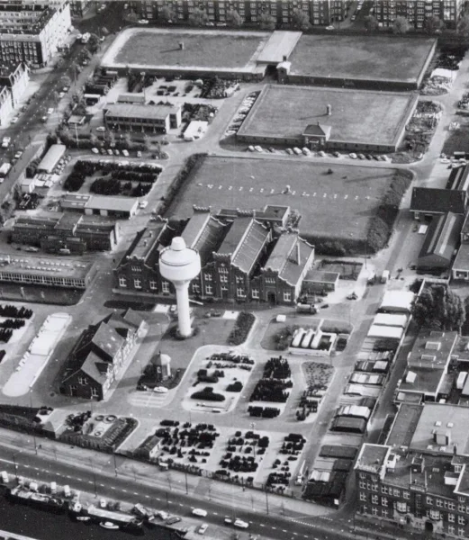 Afbeelding uit: oktober 1969. Het pompgebouw en het reservoir uit 1923 liggen achter het machinegebouw en het oudste reservoir.