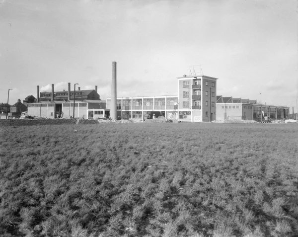 Afbeelding uit: november 1953. Het eerste deel van het Fiatcomplex in aanbouw. Het hoge gebouw op de achtergrond is de stokerij van de Zuidergasfabriek.