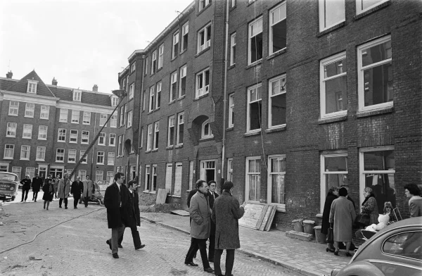 Afbeelding uit: april 1970. Journalisten, ambtenaren en buurtbewoners bekijken de woningen aan de Langkatstraat tijdens een opknapbeurt.