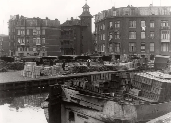 Afbeelding uit: 1934. Het zuidelijke deel van de markt, nu geheel verdwenen. Het gebouw met torentje (destijds Marnixstraat 240) was een woon- en winkelhuis uit 1902, ontworpen door H. Bonda. Foto collectie Spaarnestad.