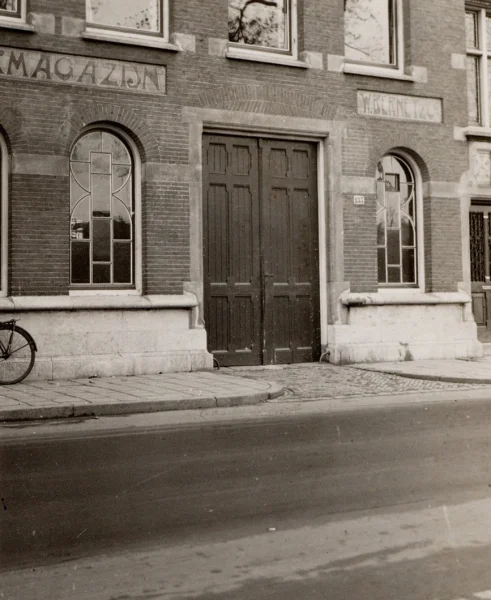 Afbeelding uit: circa 1920. Een deel van de oorspronkelijke pui aan de Amstel. "IJzermagazijn"  en "W. Bernet & Cº"
Bron afbeelding: SAA, bestand OSIM00003000267.