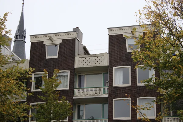 Afbeelding uit: oktober 2025. Enkele details: kroonlijsten, trapeziumvormige ramen, geperforeerd balkonhek.