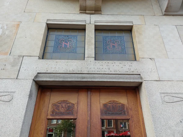 Afbeelding uit: oktober 2025. De N van Neptunus komt terug in het houtsnijwerk op de deur en in de ramen boven de deur.