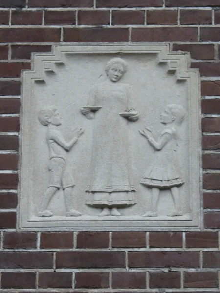 Afbeelding uit: december 2025. De hongerigen spijzen: een vrouw geeft de kinderen kommetjes met eten.