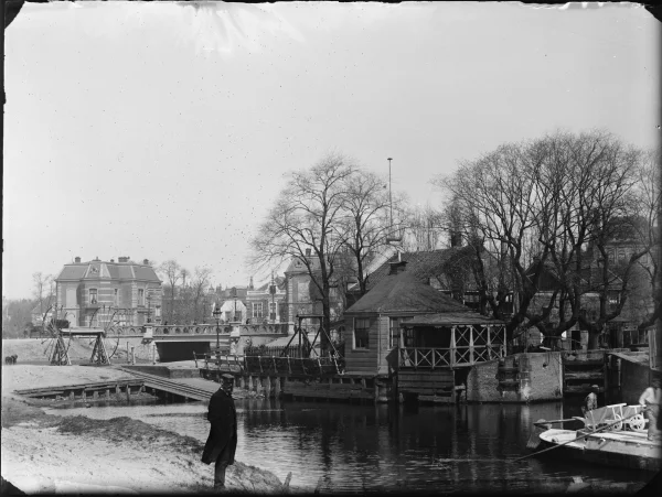 Afbeelding uit: 1891. Het water op de voorgrond is de Boerenwetering. Links staat de overhaal waarmee schuiten naar het hogere stadswater getrokken konden worden. Geheel rechts de schutsluis, voor grotere schepen. In het midden het Polderhuis. De brug op de achtergrond ligt in de Stadshouderskade.