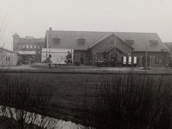 Afbeelding uit: december 1949. Oostgevel van het machinegebouw. Op het reclamebord staat "Bezoek restaurant Schiphol".
Bron afbeelding: Stadsarchief.