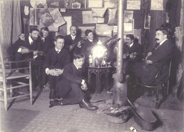 Afbeelding uit: circa 1908. Muzikale scène in de Jan Steenzolder. Geheel links Leo Gestel, naast hem collega-schilder Piet van der Hem. De foto komt vermoedelijk uit een album van Bon Ingen-Housz, collectie Stadsarchief Breda.
