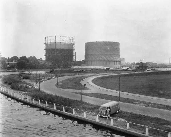 Afbeelding uit: augustus 1957. Twee gashouders. Op de voorgrond de Joan Muyskenweg.