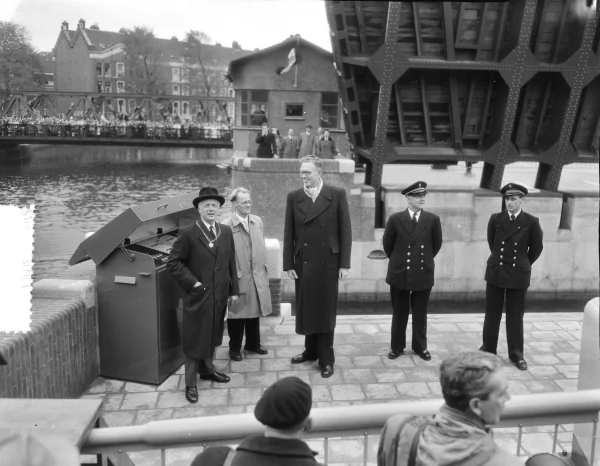 Afbeelding uit: oktober 1954. Burgemeester d'Ailly (links) heeft net op een knop gedrukt om de brug officieel te openen.