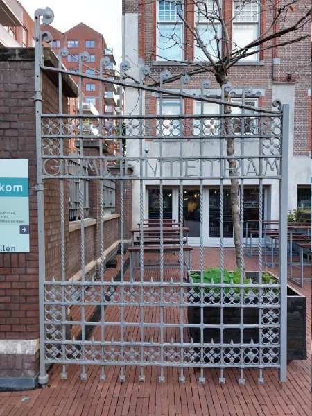 Afbeelding uit: september 2026. Smeedijzeren hek met de naam Gemeentetram. Op het andere deel staat Anno 1909.