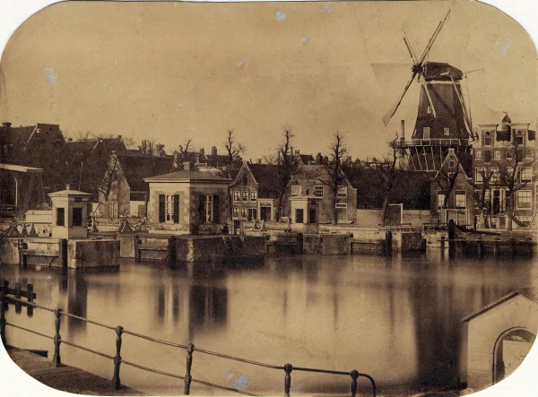 Afbeelding uit: circa 1870. Op het terrein waar later Carré kwam stonden tot 1876 een verfmolen en enkele bijgebouwen. De molen is in 1874 nog door Claude Monet geschilderd.
Bron afbeelding: Stadsarchief.
