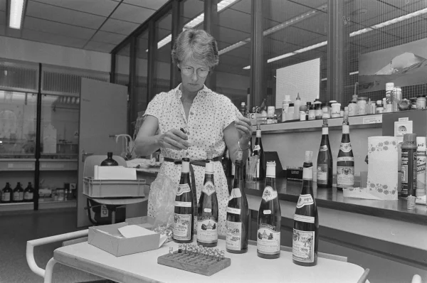 Afbeelding uit: juli 1985. Een medewerkster van de Keuringsdienst onderzoekt Oostenrijkse wijn. Aanleiding was het schandaal waarbij sommige producenten het giftige antivriesmiddel diethyleenglycol hadden toegevoegd aan hun wijn om de smaak te versterken.