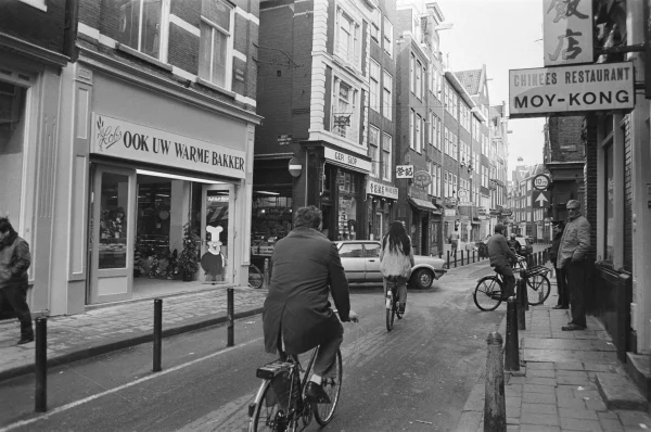 Afbeelding uit: november 1984. In november 1984 opende op de tegenovergelegen hoek een filiaal van bakker Lobs. Het was de eerste nieuwe winkel in het kader van het offensief waarmee de gemeente en ondernemers de Zeedijk wilde heroveren op de drugshandel.
