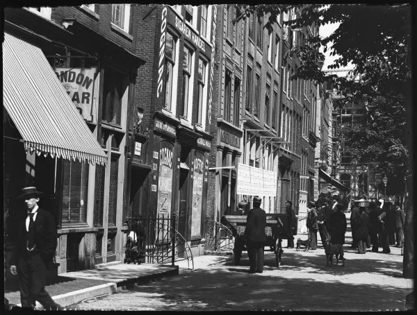 Afbeelding uit: 1897. Situatie in 1897, nog voor de komst van het nieuwe Handelsbladgebouw. Op de borden wordt de uitslag van een verkiezing bekendgemaakt.