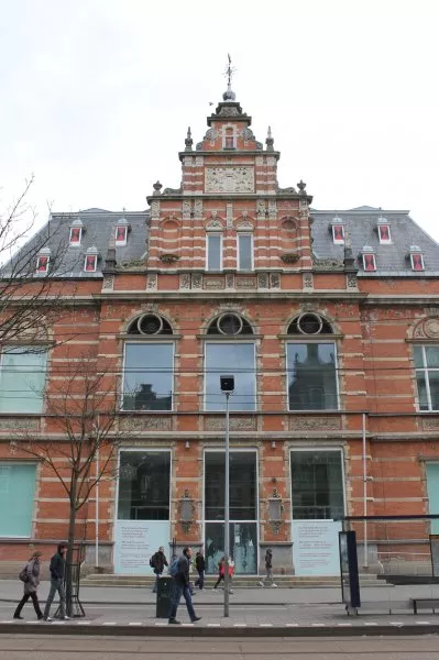 Afbeelding uit: april 2012. De oorspronkelijke hoofdingang. Bovenin een windvaan in de vorm van een koggeschip, het oude zegel van Amsterdam.