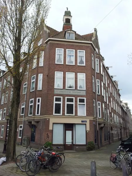 Afbeelding uit: april 2012. Hoek Baarsstraat - Vaartstraat (rechts). Op het tegeltableau staat de tekst "Woningstichting Patrimonium".