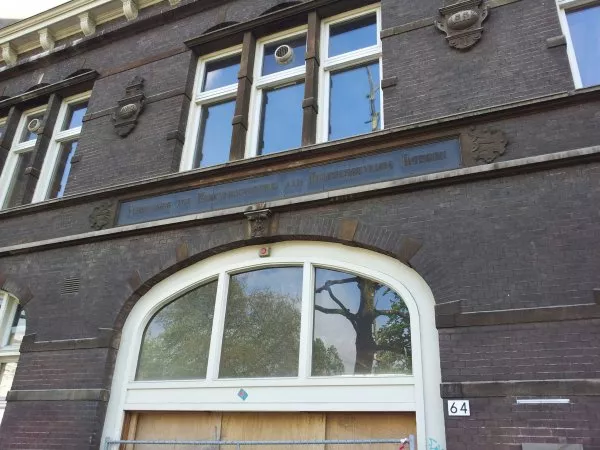 Afbeelding uit: mei 2012. "Vereeniging tot Werkverschaffing aan Hulpbehoevende Blinden", staat er op het fries. Daarboven, aan weerszijden van het raam: 'Anno' en '1892'.