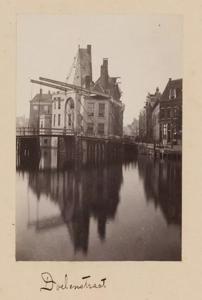 Afbeelding uit: 1864. De voorganger van de huidige brug. Op de achtergrond staat nog de toren Swijgh Utrecht; later kwam daar het Doelenhotel.